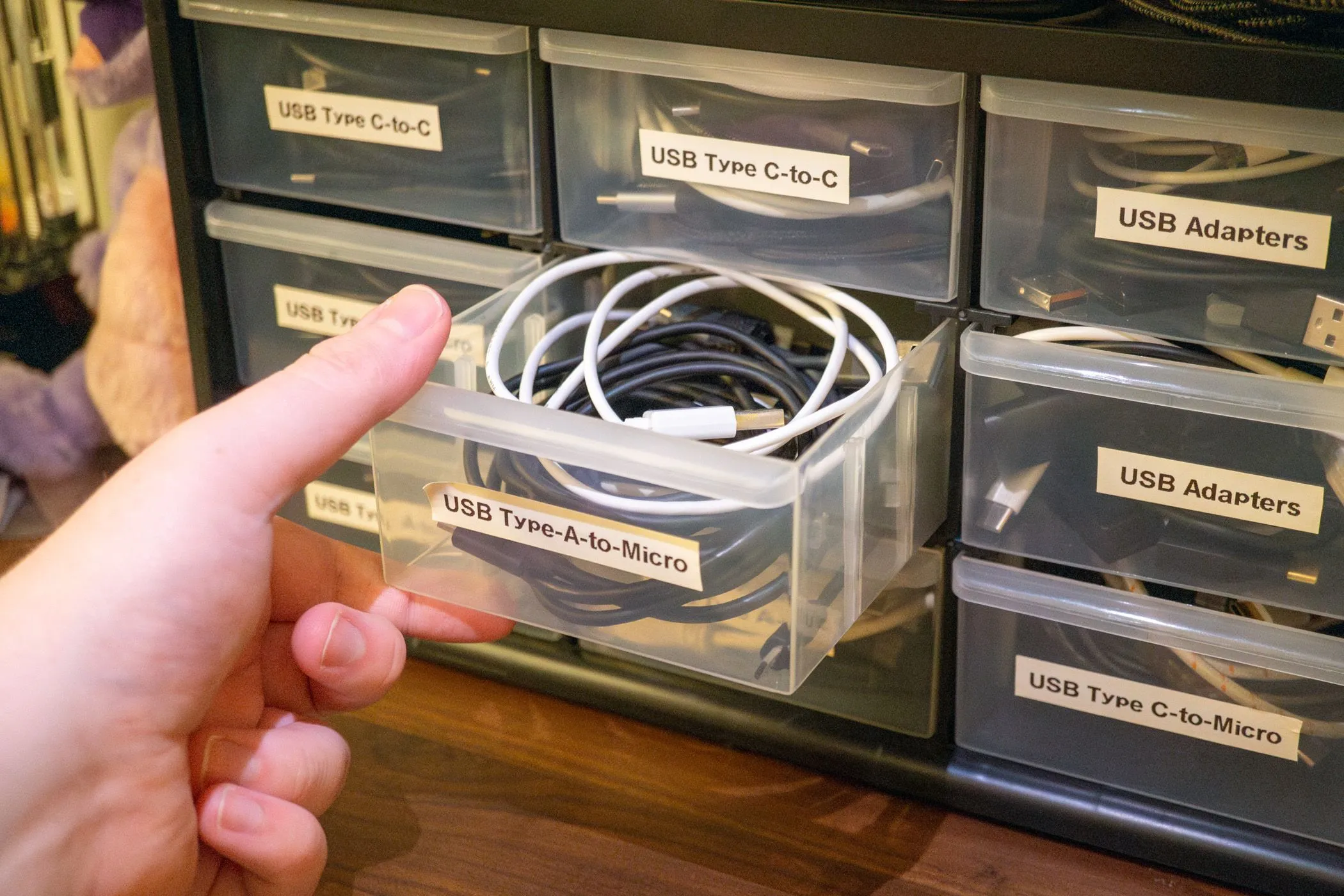 Ngăn kéo tủ nhựa chứa đầy dây cáp USB được mở ra, minh họa giải pháp tổ chức và lưu trữ dây cáp gọn gàng.