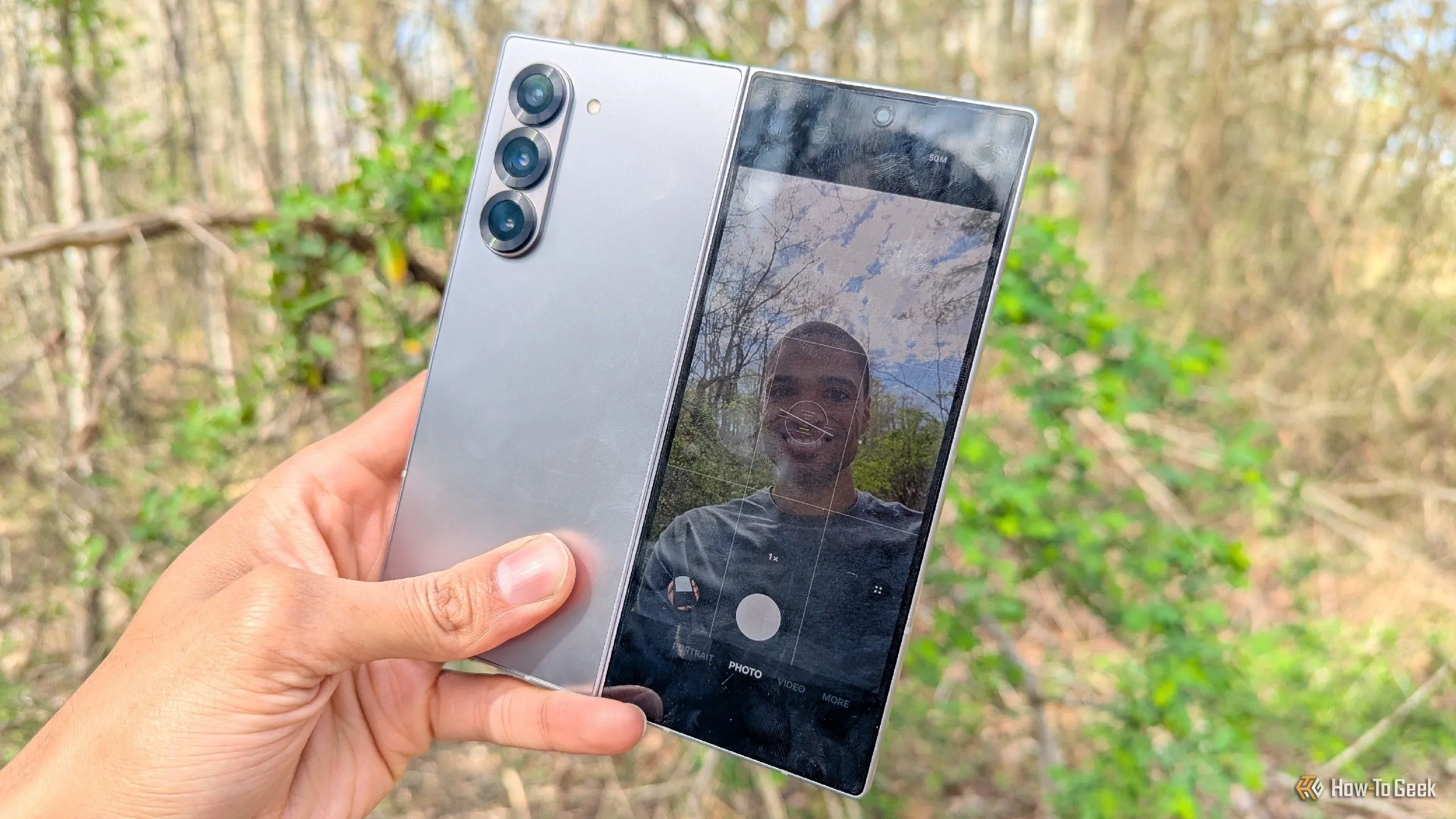 Người dùng đang chụp ảnh selfie bằng camera sau chất lượng cao của Galaxy Z Fold 6, với màn hình ngoài hiển thị hình ảnh.