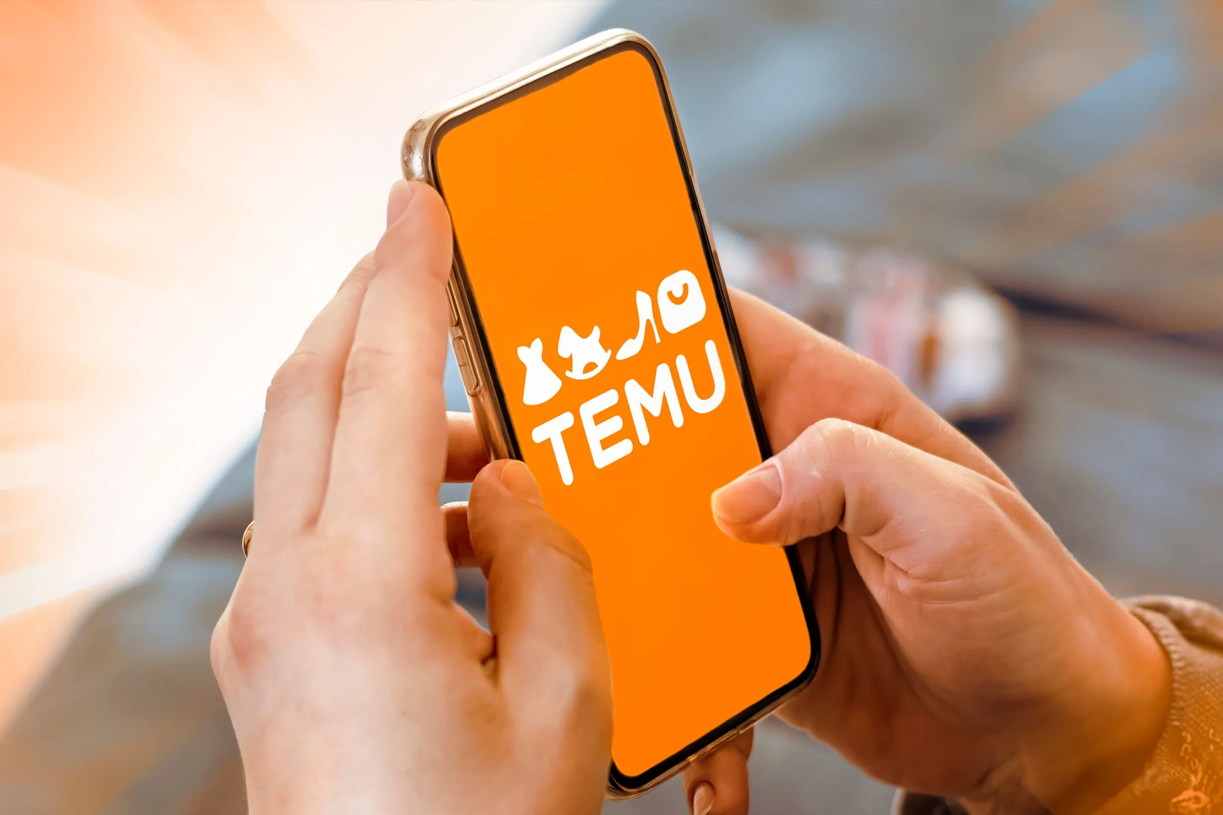 Ứng dụng di động Temu trên điện thoại với logo đặc trưng và giao diện mua sắm.