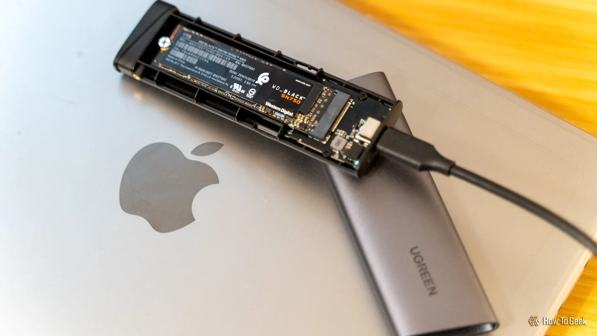 Vỏ đựng SSD M.2 NVMe USB-C UGREEN chứa SSD WD_BLACK SN750, thể hiện giải pháp lưu trữ di động